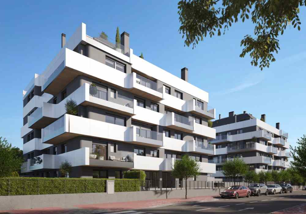 en la imagen se ve un bloque de viviendas con fachada blanca y balcones.