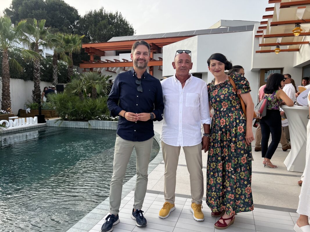 La imagen muestra a Miguel Ángel Solá, Director de GTM Ingeniería, junto a Izaskun Chinchilla, arquitecta, de pie y sonriendo a la cámara. Detrás de ellos se encuentra la casa sostenible diseñada por Izaskun Chinchilla, conocida por su enfoque de cero impacto ambiental. La estructura es un ejemplo de arquitectura ecológica e innovadora, destacándose en el entorno como una construcción moderna y respetuosa con el medio ambiente.
